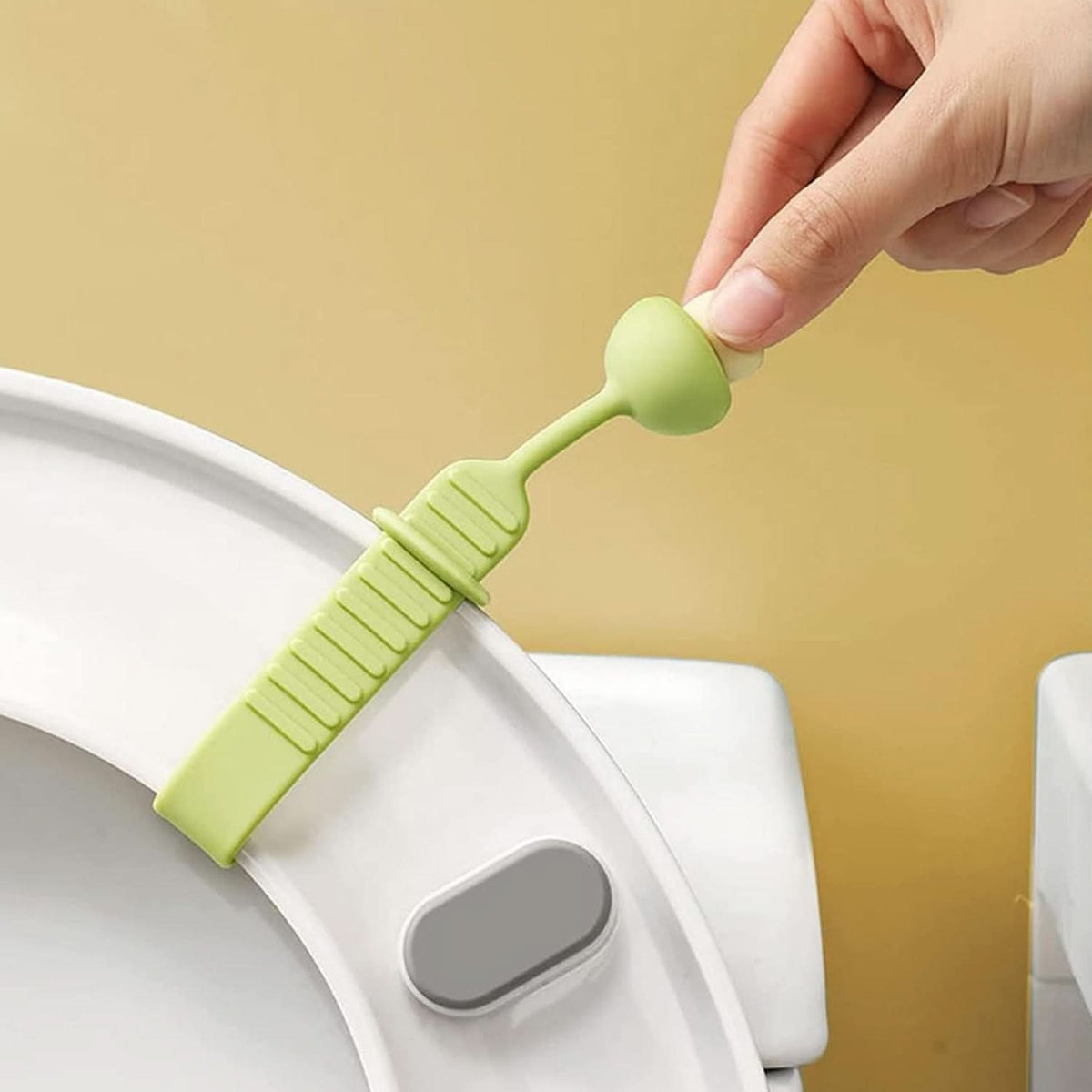 Silicone toilet seat lifter band handle attached to a toilet lid